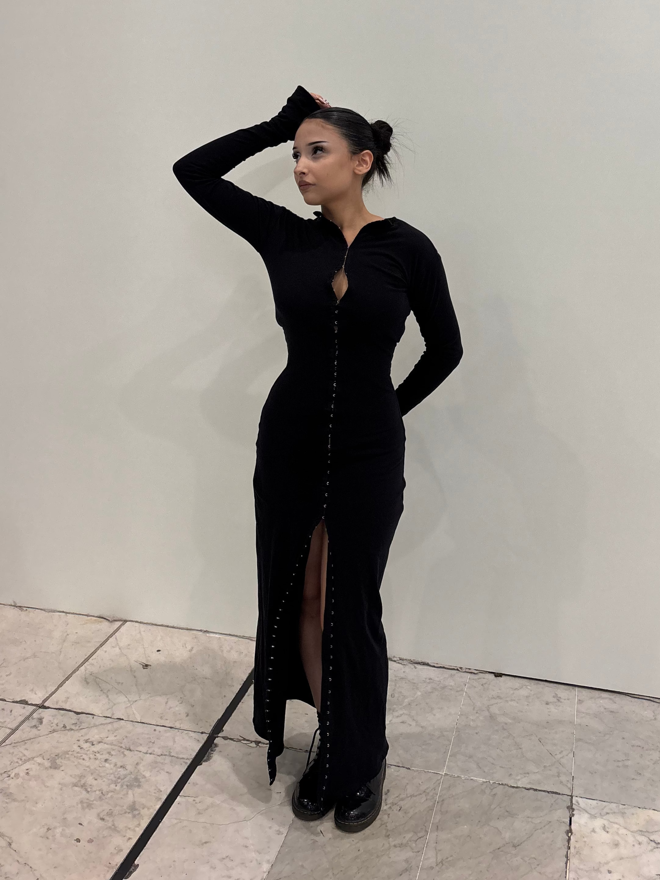 Robe à crochets noire KIORA - vue de profil, tombé de la robe longue avec ouverture sur les jambes